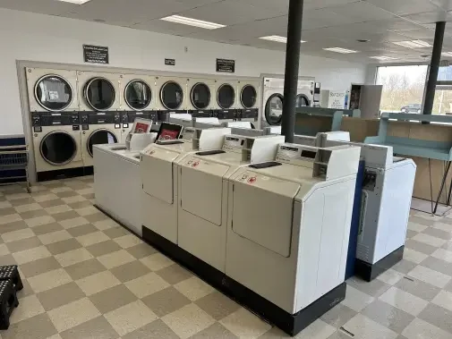 Kiel Washbasket Laundromat interior view of washers, dryers and prep tables.